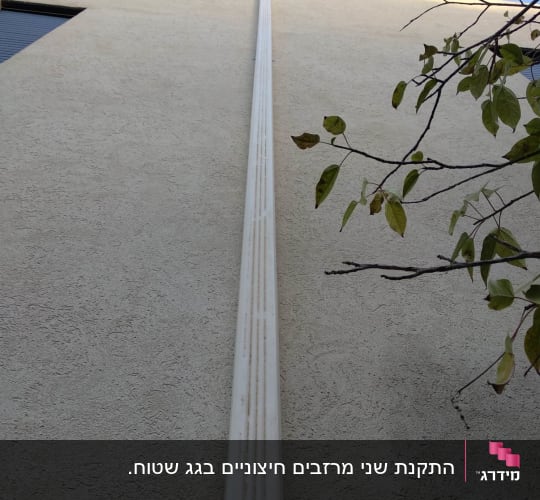 מרזב לבן מחובר לגג בניין